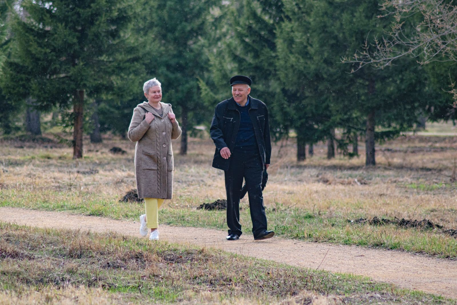 Active senior couple walking comfortably together on a park path