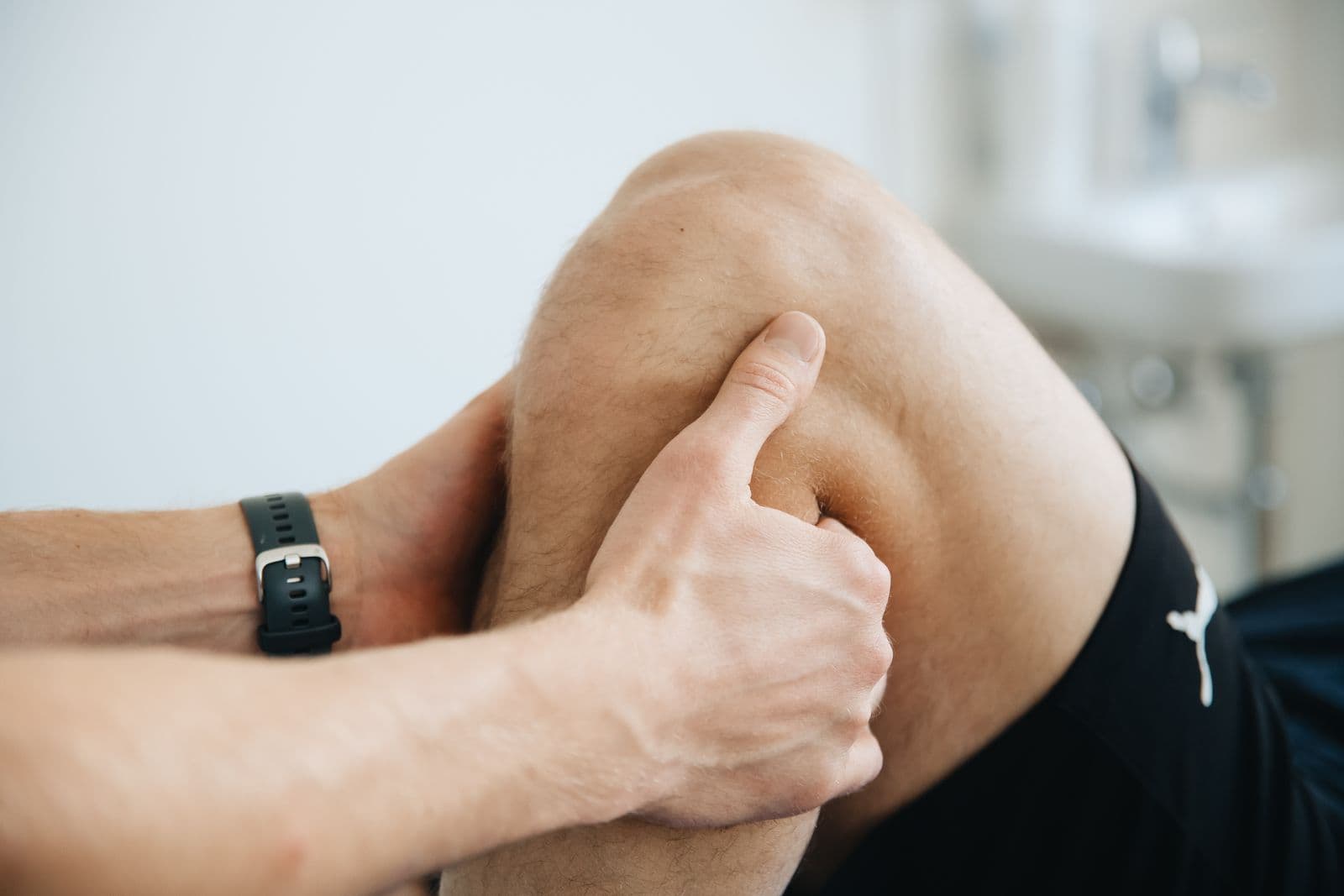 Clinician examining and treating a patient's knee